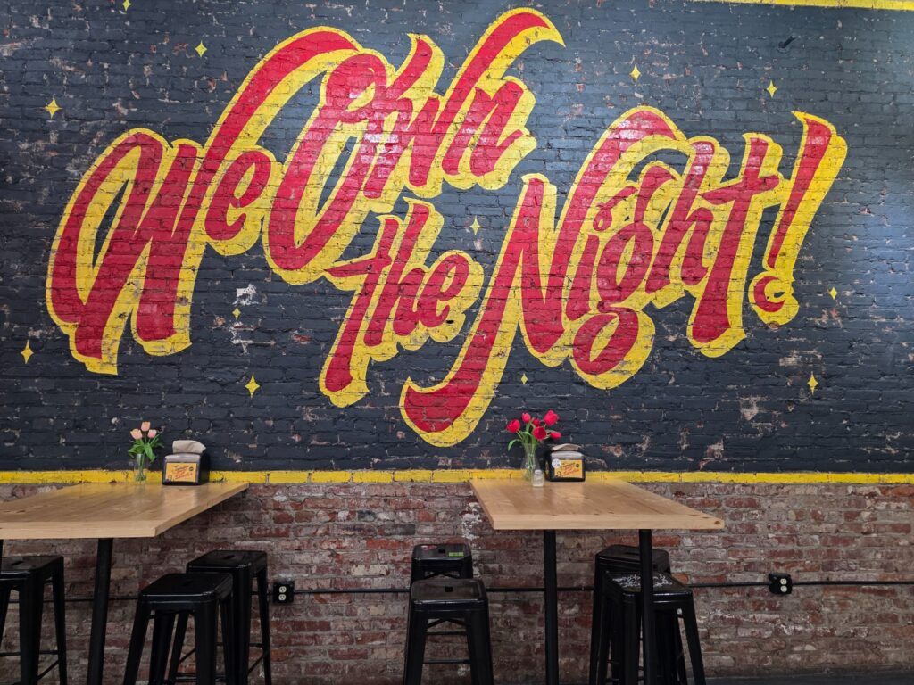 Colorful nightlife mural on a brick wall