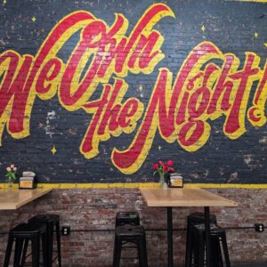 Colorful nightlife mural on a brick wall