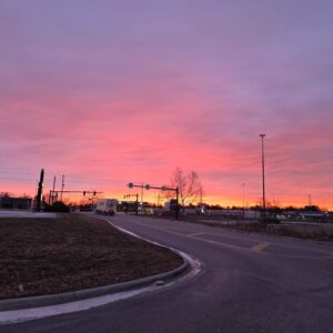 Pink and orange dawn above an open roadway